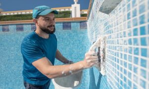 A person brushing a pool wall