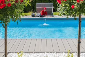 A person in a red uniform by a pool